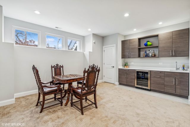 a view of kitchen with stainless steel appliances granite countertop a dining table chairs and a refrigerator
