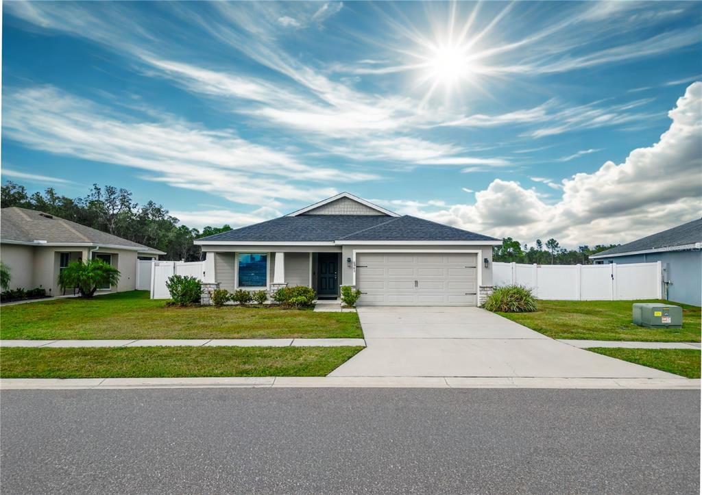 6945 Gideon Circle Zephyrhills, FL 33541 - Photo 1 of 45 a front view of a house with a yard and garage