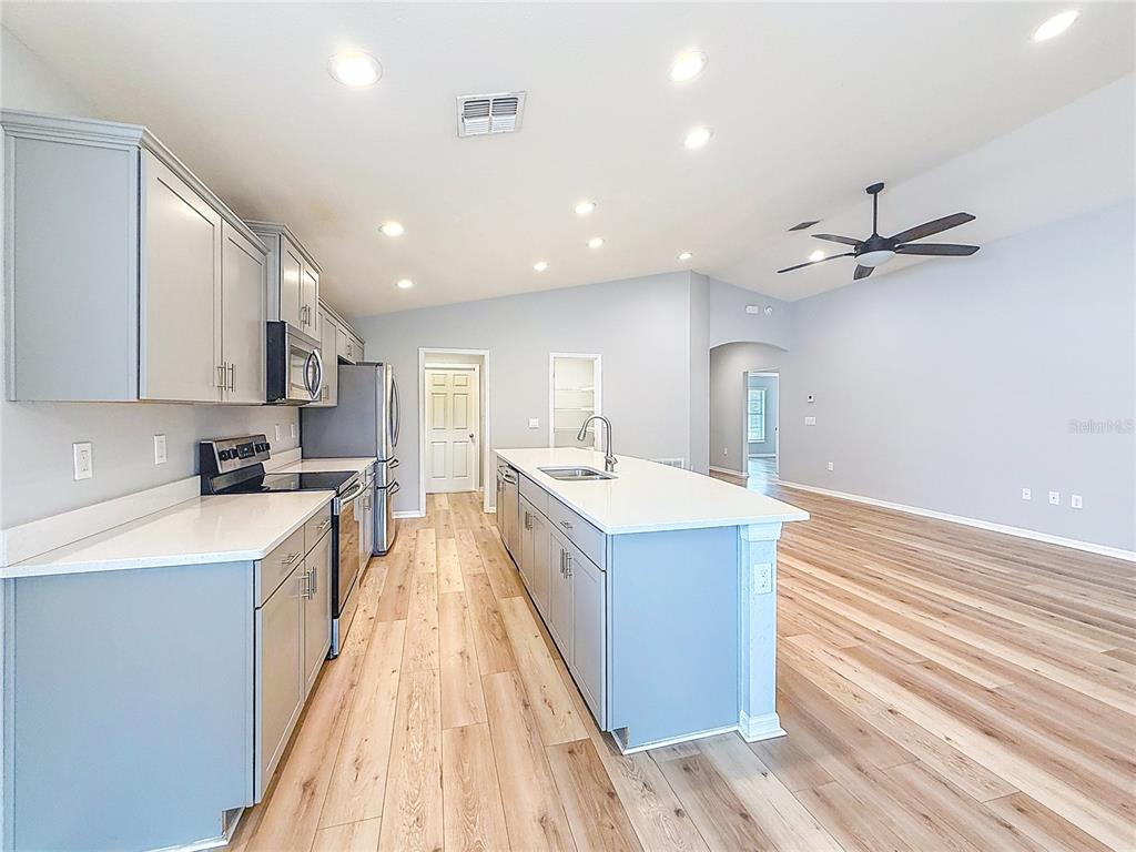 6945 Gideon Circle Zephyrhills, FL 33541 - Photo 18 of 45 a large kitchen with stainless steel appliances lots of counter space and a sink