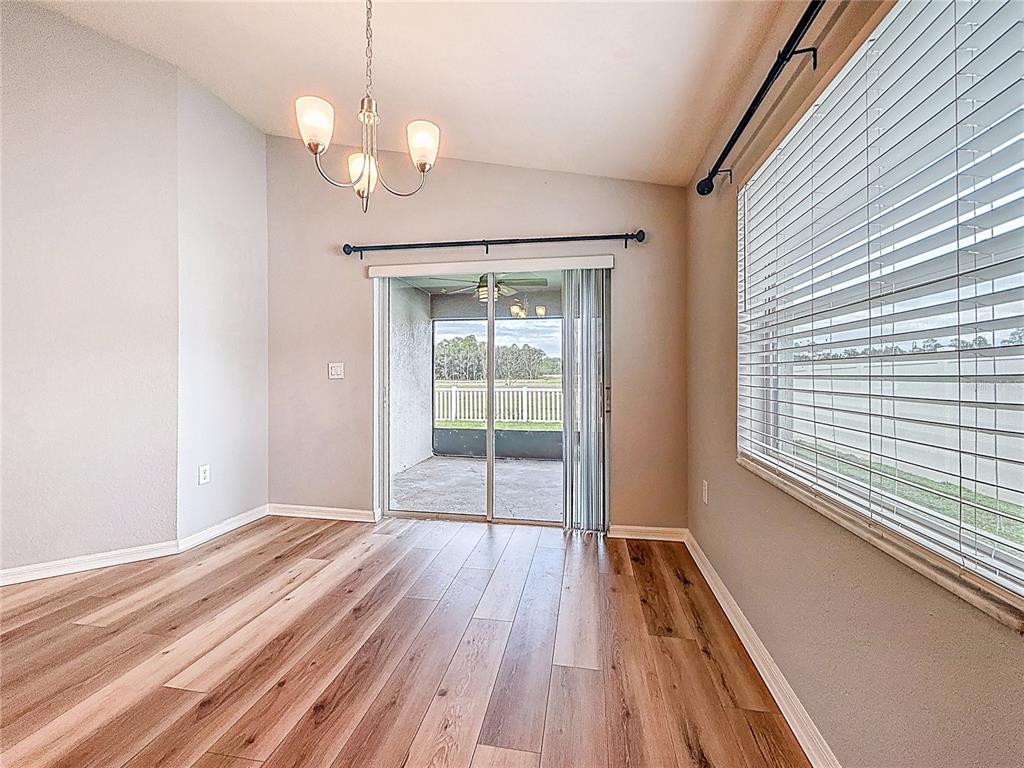 6945 Gideon Circle Zephyrhills, FL 33541 - Photo 20 of 45 a view of an empty room with wooden floor and a window