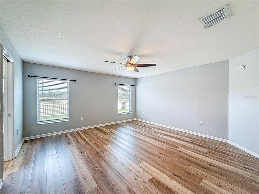 6945 Gideon Circle Zephyrhills, FL 33541 - Photo 29 of 45 a view of an empty room with wooden floor and a window