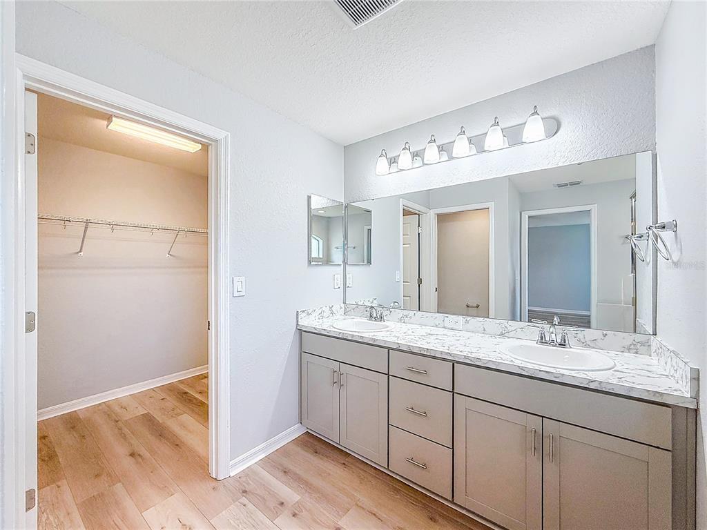 6945 Gideon Circle Zephyrhills, FL 33541 - Photo 32 of 45 a bathroom with a double vanity sink and a mirror