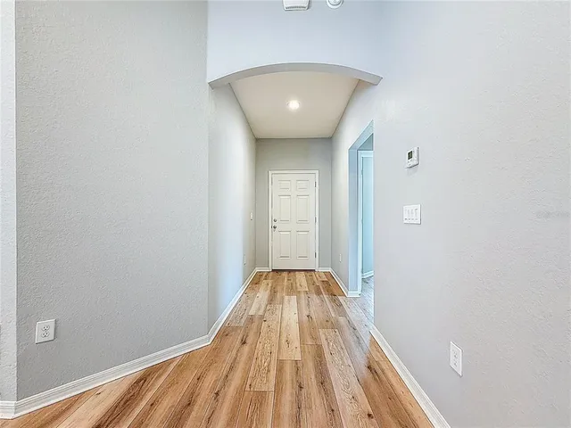 a view of a room with wooden floor and entryway