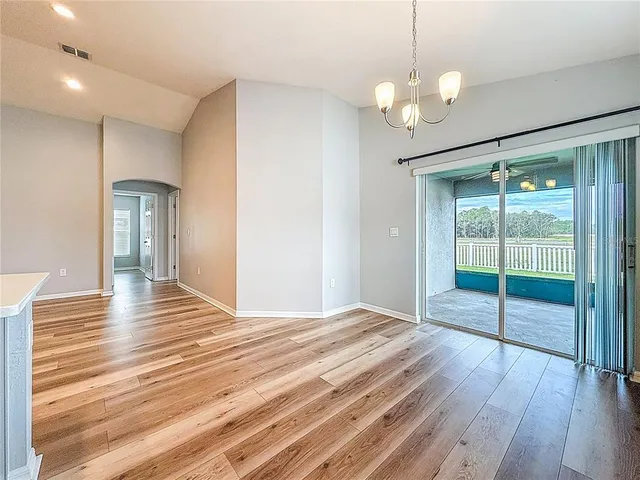 an empty room with a window and a ceiling fan