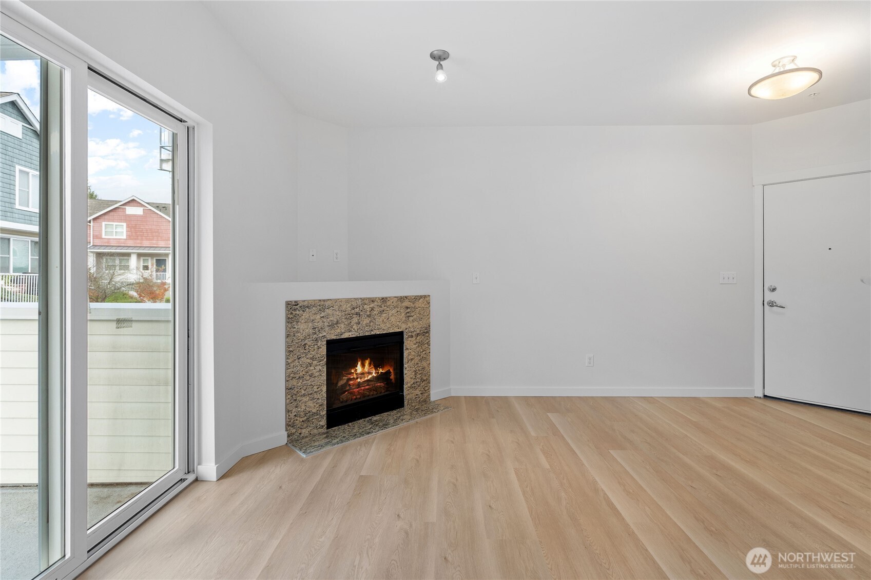 2840 Southwest Raymond Street, Unit 203 Seattle, WA 98126 - Photo 4 of 39 a view of an empty room with wooden floor fireplace and a window