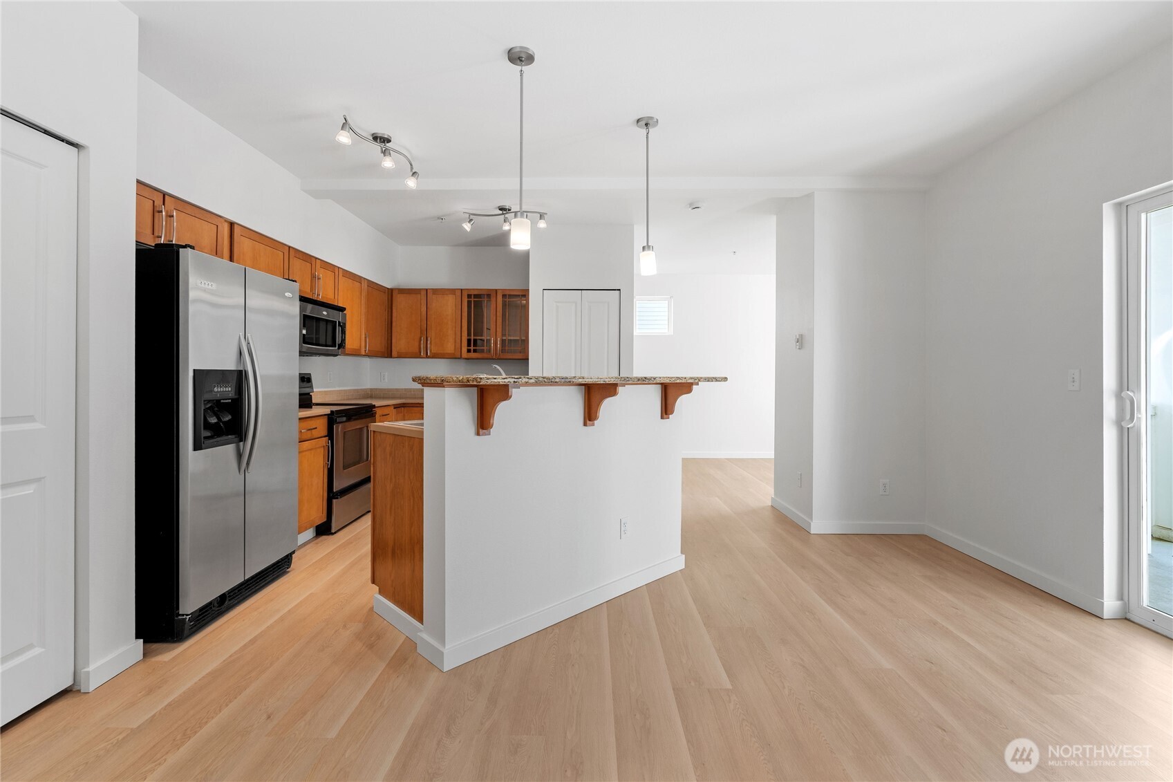 2840 Southwest Raymond Street, Unit 203 Seattle, WA 98126 - Photo 5 of 39 a view of a kitchen with refrigerator and wooden floor