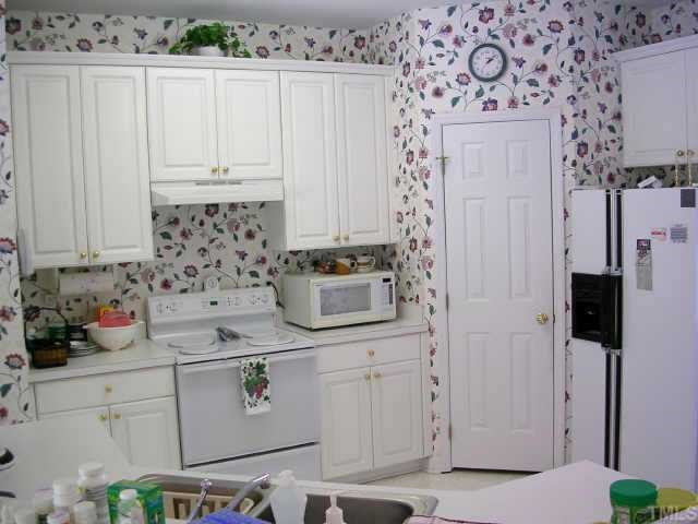 8633 Harps Mill Road Raleigh, NC 27615 - Photo 5 of 10 The kitchen has white raised panel cabinets and a large breakfast bar Other