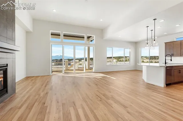 a view of an empty room with kitchen and a window