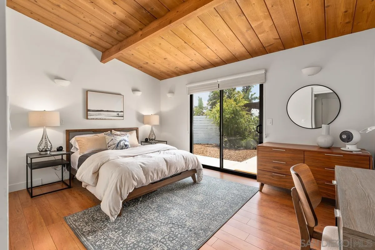 465 Glencrest Drive Solana Beach, CA 92075 - Photo 15 of 28 a bedroom with a bed a mirror on desk and wooden floor
