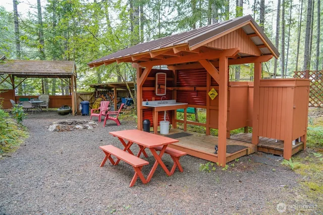 a backyard of a house with barbeque oven table and chairs