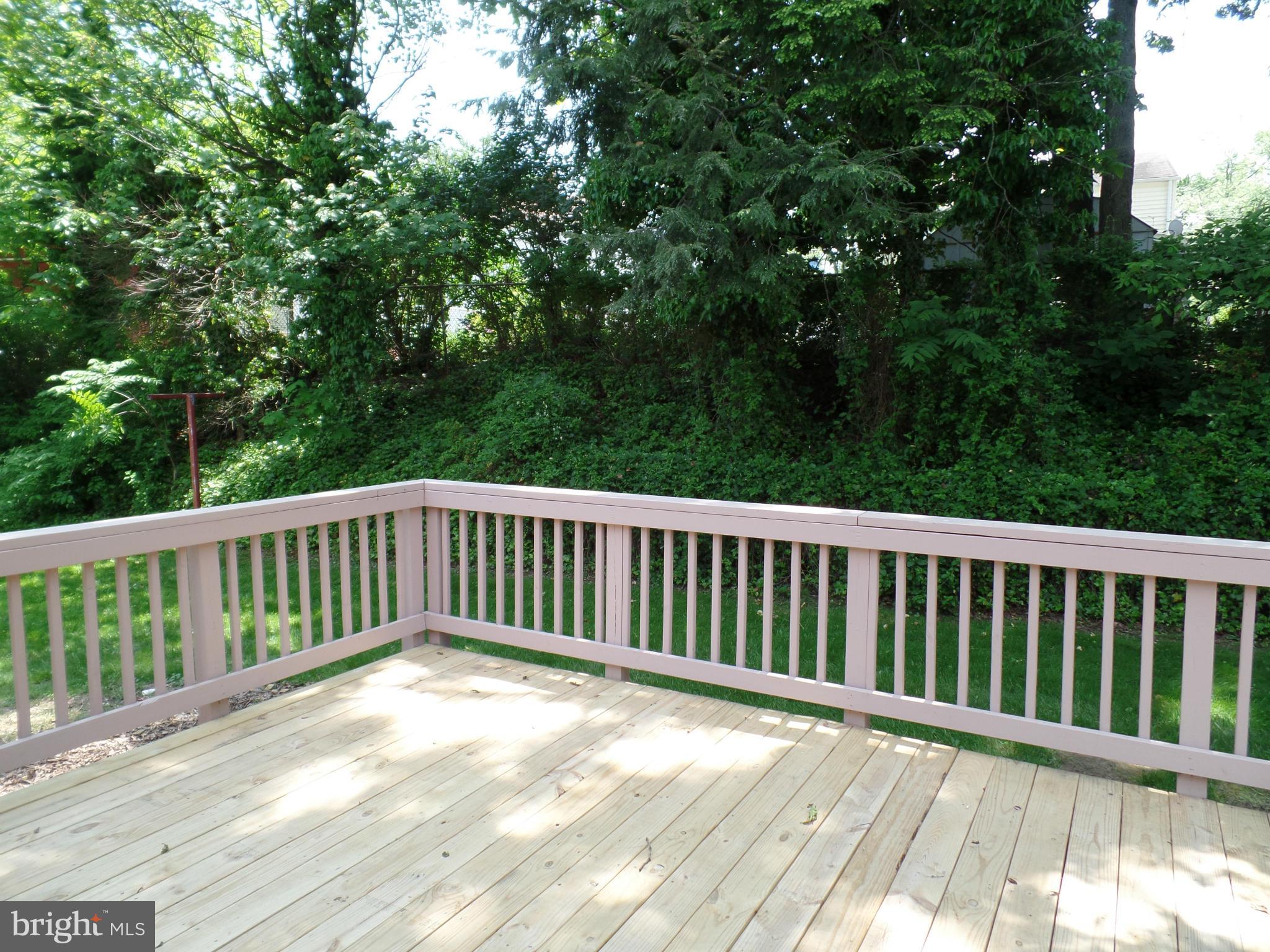 2822 Denley Place Silver Spring, MD 20906 - Photo 16 of 18 a balcony with wooden floor and trees in the background