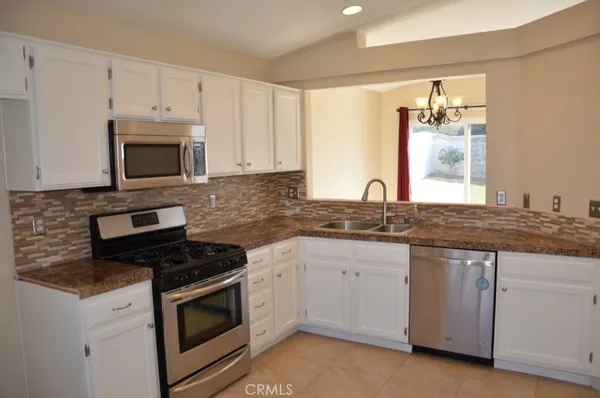 a kitchen with granite countertop white cabinets and white appliances