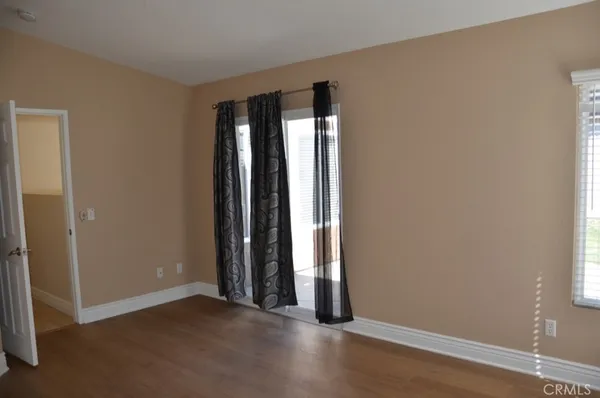 an empty room with wooden floor and closet