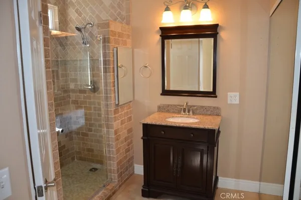 a bathroom with a granite countertop shower and a toilet