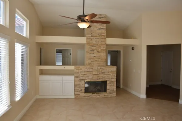 a view of a livingroom with a fireplace a chandelier and entryway