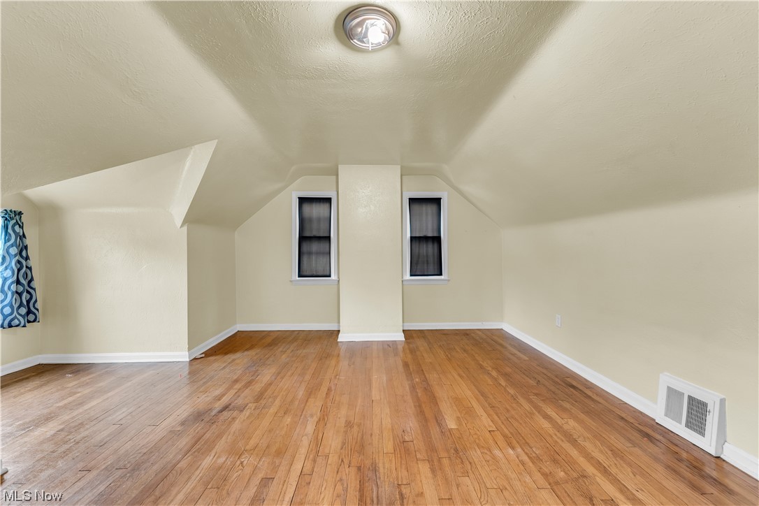 5619 Dunham Road Maple Heights, OH 44137 - Photo 14 of 19 Additional living space featuring a textured ceiling, light hardwood flooring, and vaulted ceiling