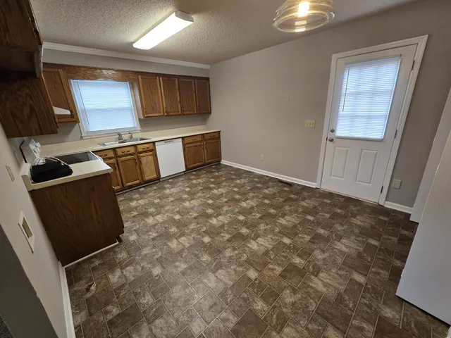a kitchen with granite countertop a stove a sink and a microwave