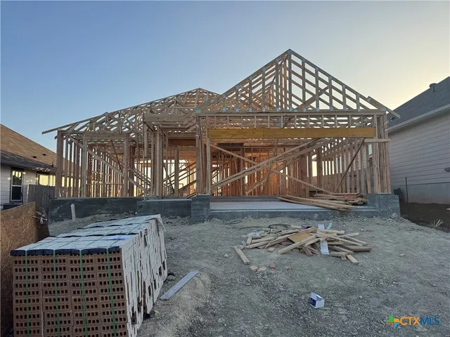 a view of a house with a yard and wooden fence