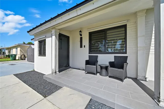 a view of a house with backyard and sitting area