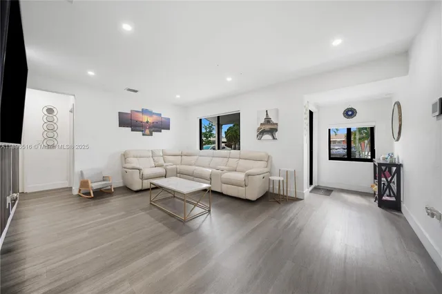 a living room with furniture and a wooden floor