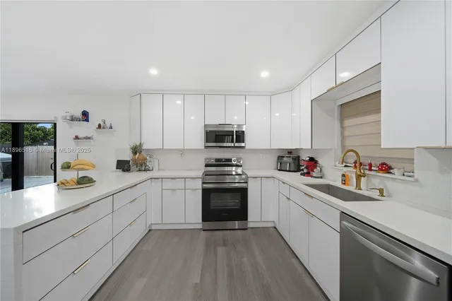 a kitchen with granite countertop white cabinets and white appliances