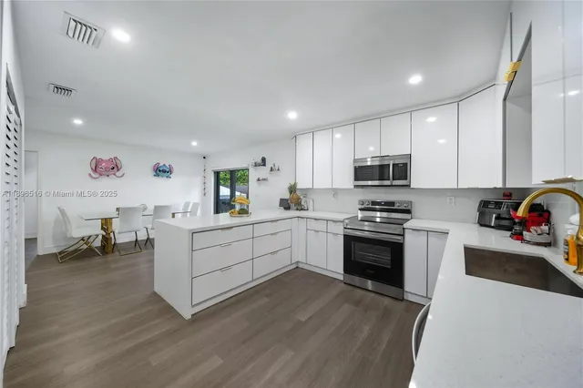 a kitchen with a sink cabinets and wooden floor
