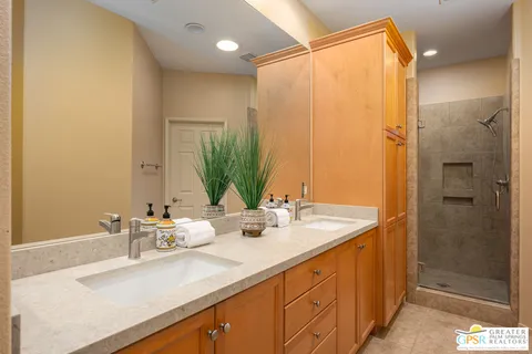 a bathroom with a double vanity sink mirror and shower