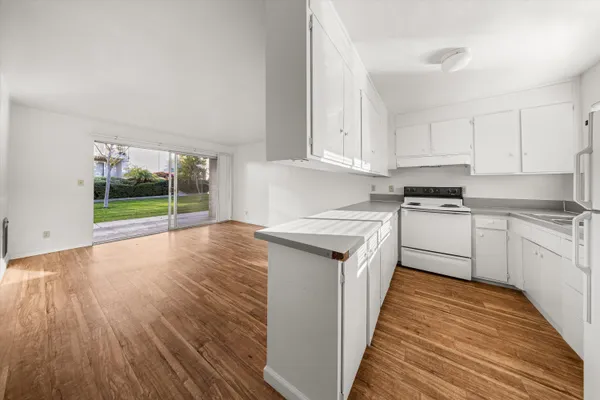 a kitchen with a sink and wooden floor