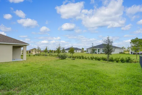 a view of a big yard with a house in the background