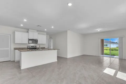 a kitchen with stainless steel appliances granite countertop a stove a sink a refrigerator and a refrigerator