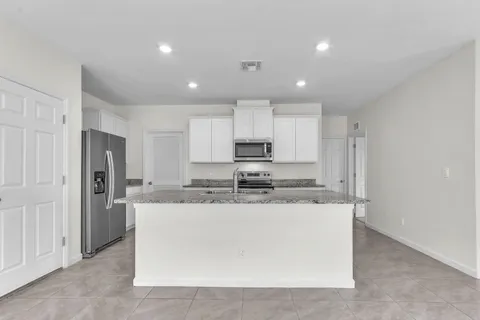 a view of a kitchen with stainless steel appliances granite countertop cabinets and a refrigerator