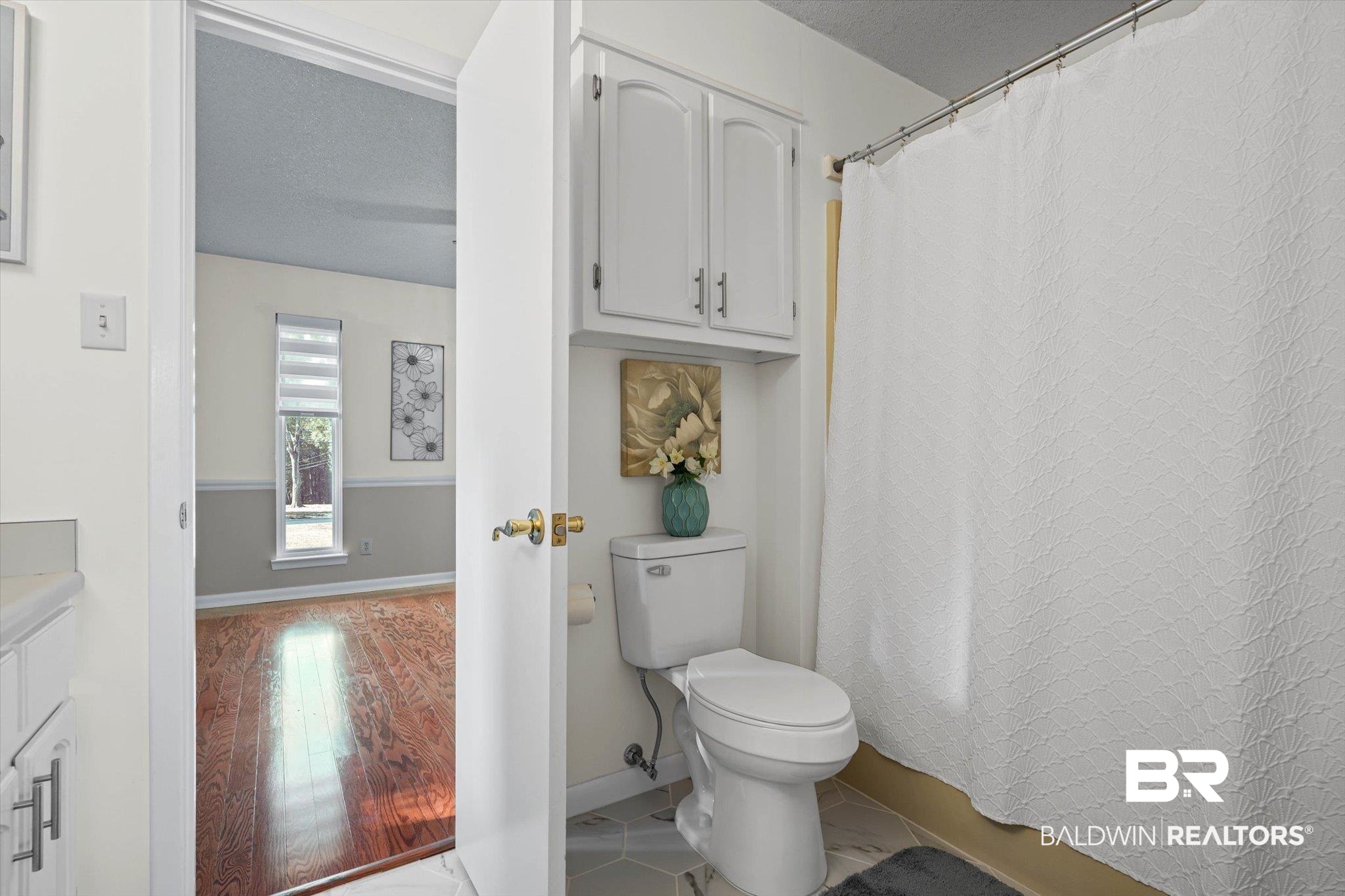 4567 Pine Avenue Saraland, AL 36571 - Photo 18 of 48 Full bathroom with curtained shower, a textured ceiling, vanity, and light wood finished floors