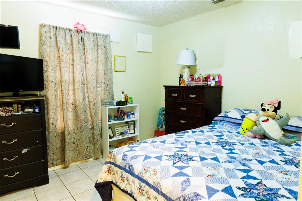 808 West Starr Avenue Pharr, TX 78577 - Photo 7 of 18 Bedroom featuring a textured ceiling and light tile patterned floors