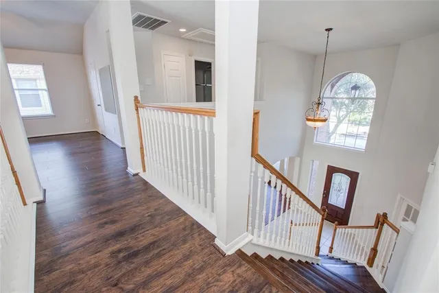 a view of a livingroom with wooden floor and a chandelier