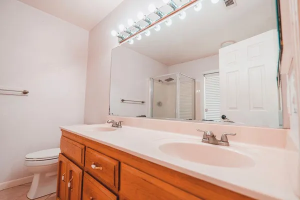a bathroom with a sink a toilet and a large mirror
