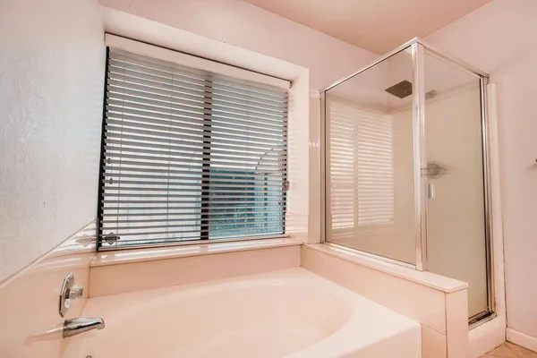 a bathroom with a bathtub and a window