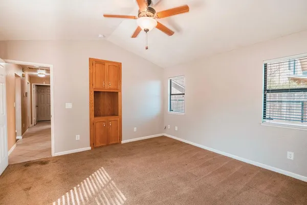 an empty room with closet and windows