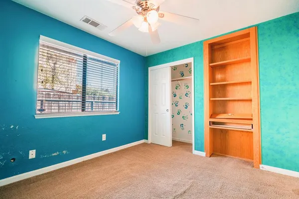 a view of an empty room with a window and a kitchen