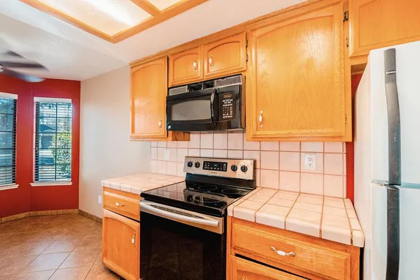 a kitchen with stainless steel appliances a stove a refrigerator and a microwave