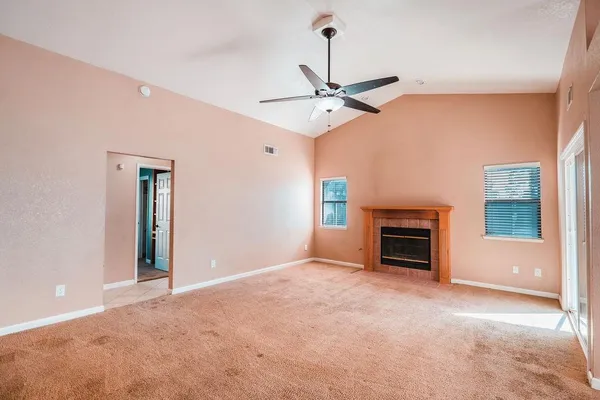 a view of an empty room with a fireplace and a window