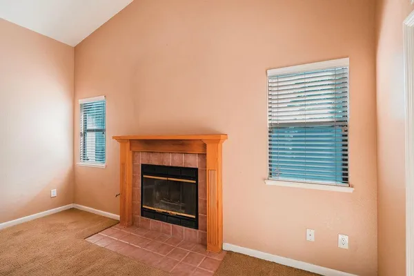 an empty room with a fireplace and a window
