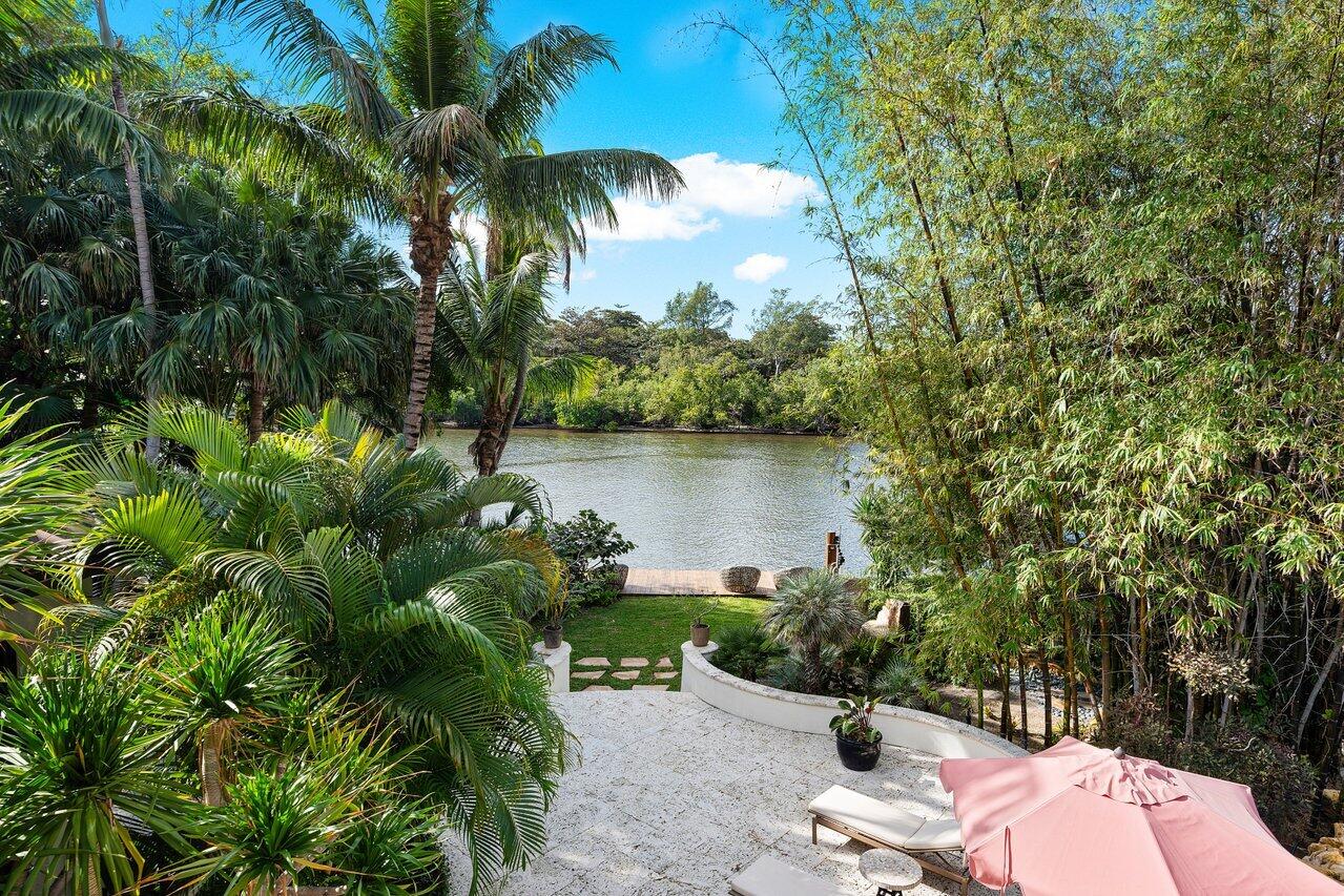 8 Driftwood Landing Road Gulf Stream, FL 33483 - Photo 17 of 67 a backyard of a house with lawn chairs plants and lake view