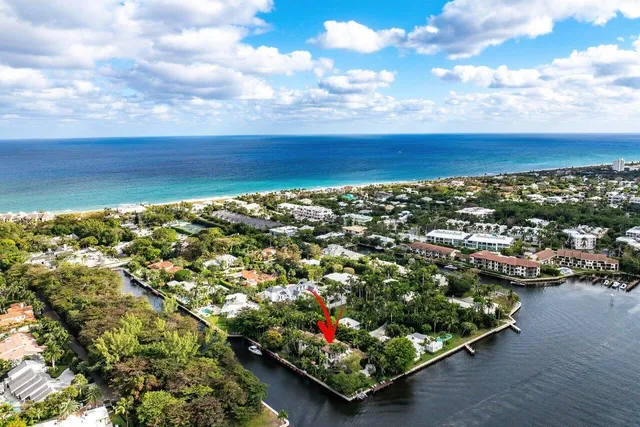 a view of residential houses with lake and trees in the background