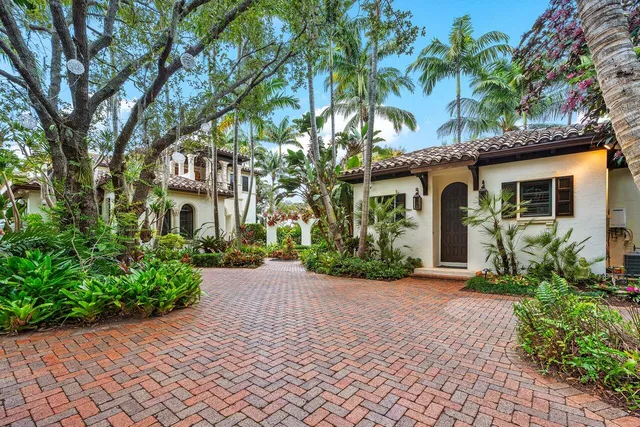 a backyard of a house with lawn chairs plants and lake view