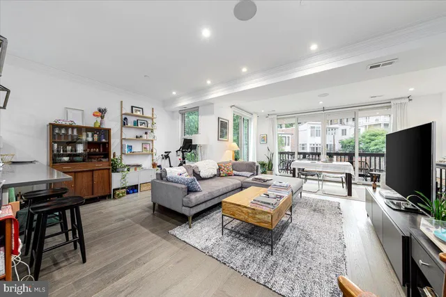 a living room with furniture a flat screen tv and a large window