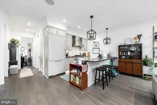 a kitchen with a refrigerator a stove top oven a sink dishwasher and white cabinets with wooden floor