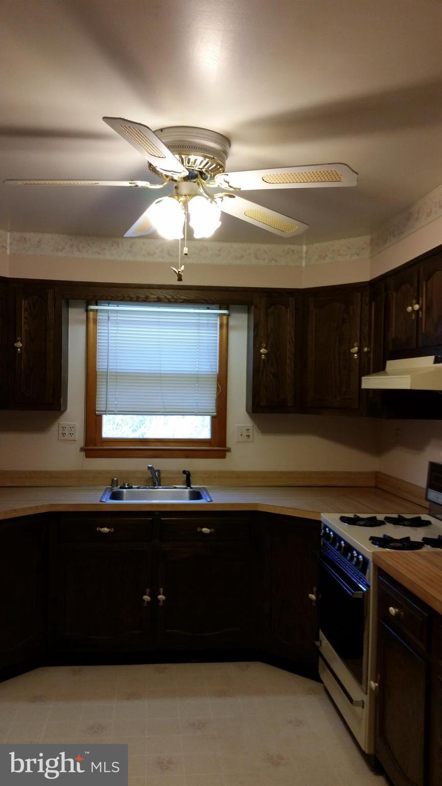 8734 Edmonston Road Berwyn Heights, MD 20740 - Photo 4 of 13 a kitchen with a sink and cabinets