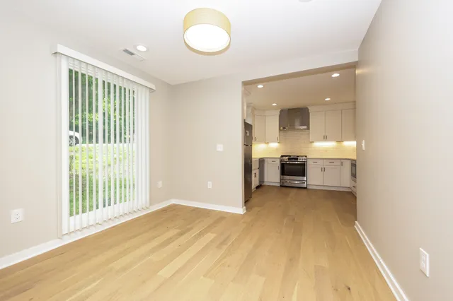 a view of a room with wooden floor and a window
