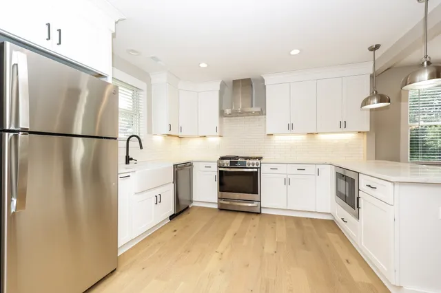 a kitchen with white cabinets and white stainless steel appliances