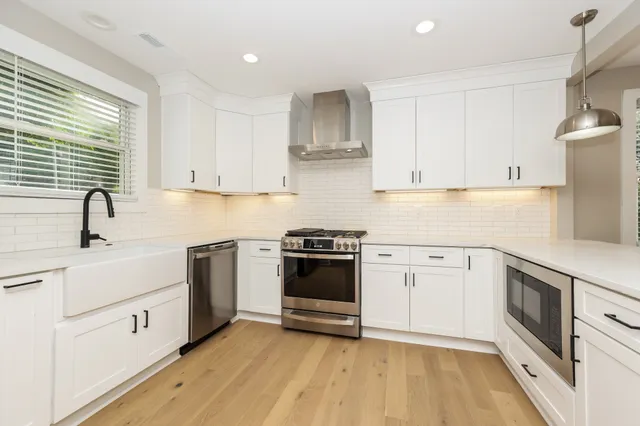 a kitchen with cabinets stainless steel appliances and sink